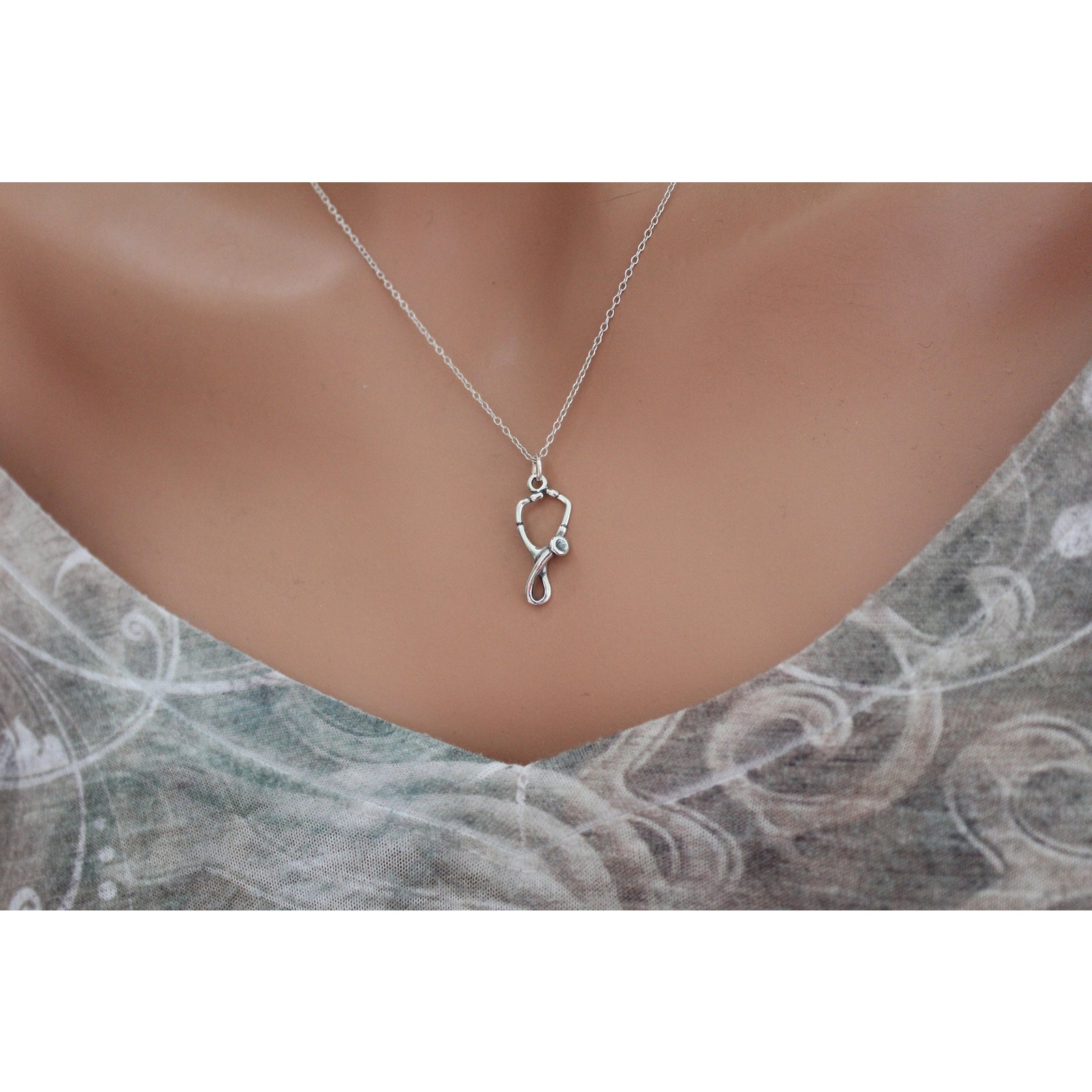 Sterling silver charm necklace photographed on a plain background for a marketplace listing